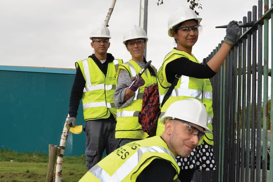 Wates volunteers painting a fence